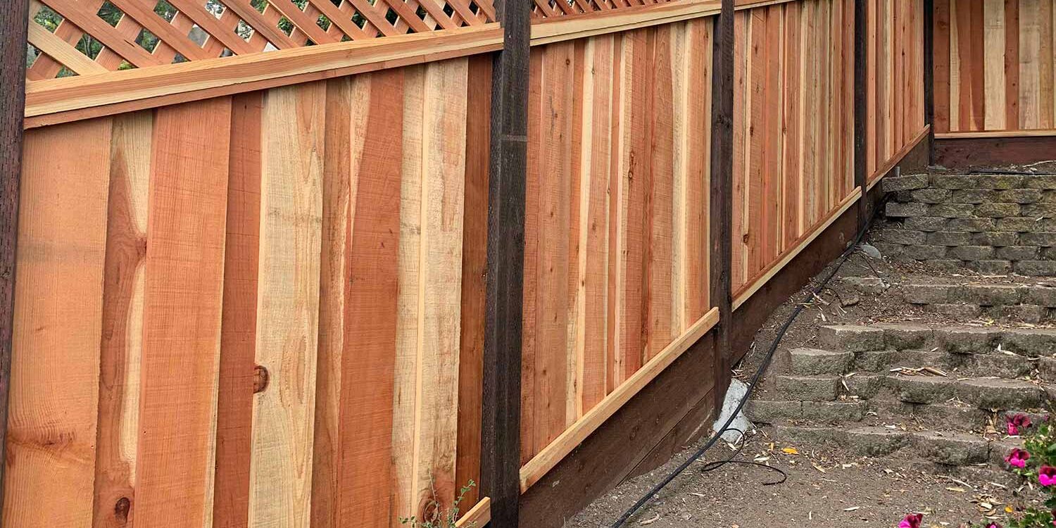Wood lattice fence along garden steps with flowers and potted plants